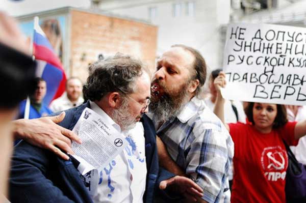 Отец Алексий Касатиков приветствует Марата Гельмана плевком